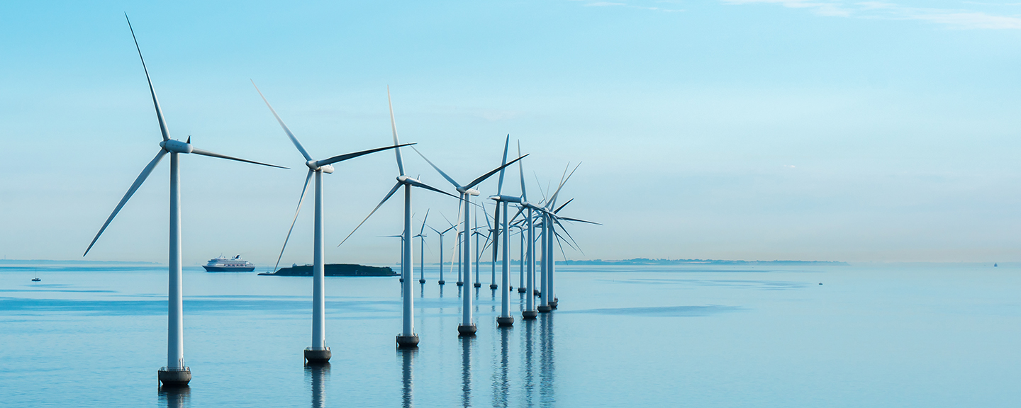 row of wind turbines in a body of smooth water