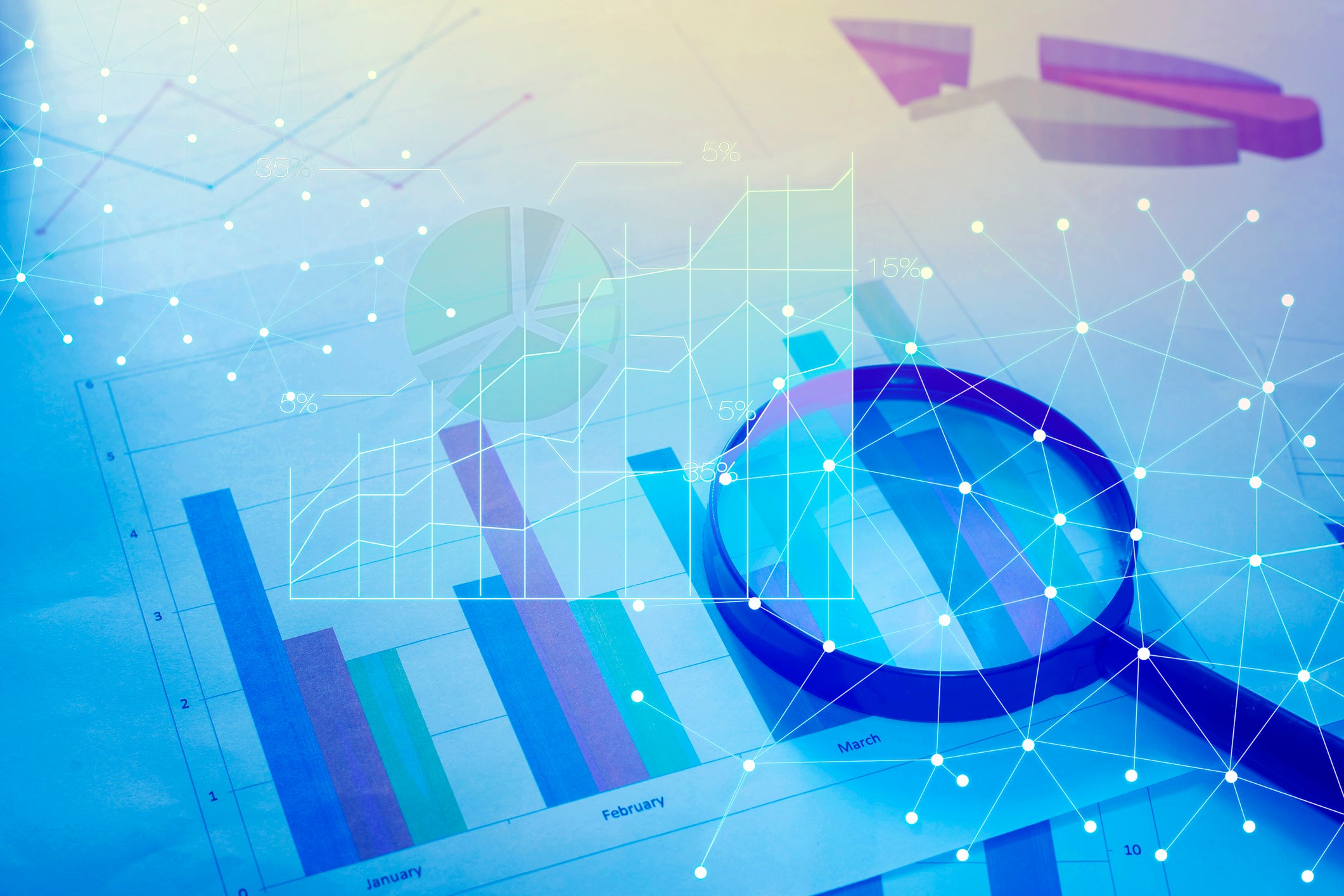 Magnifying glass and documents with analytics data lying on table