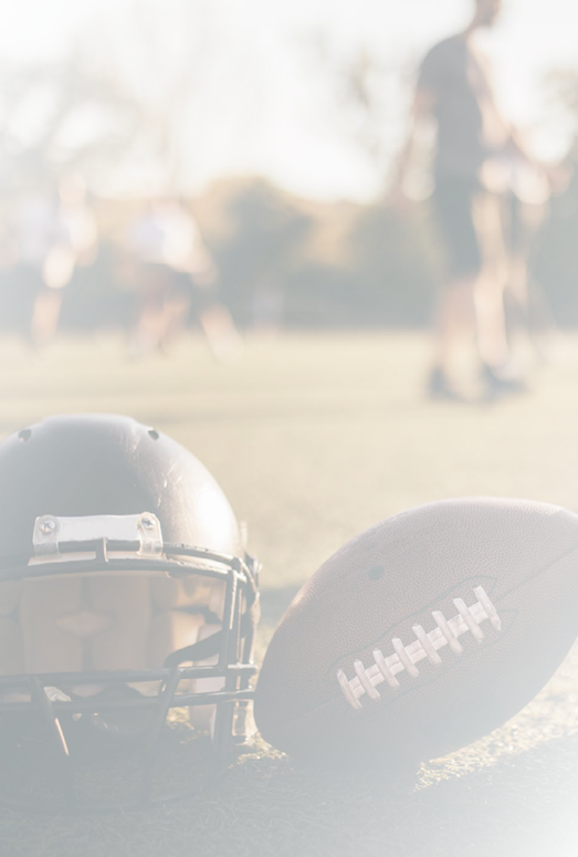 American football helmets and ball on the playing field.