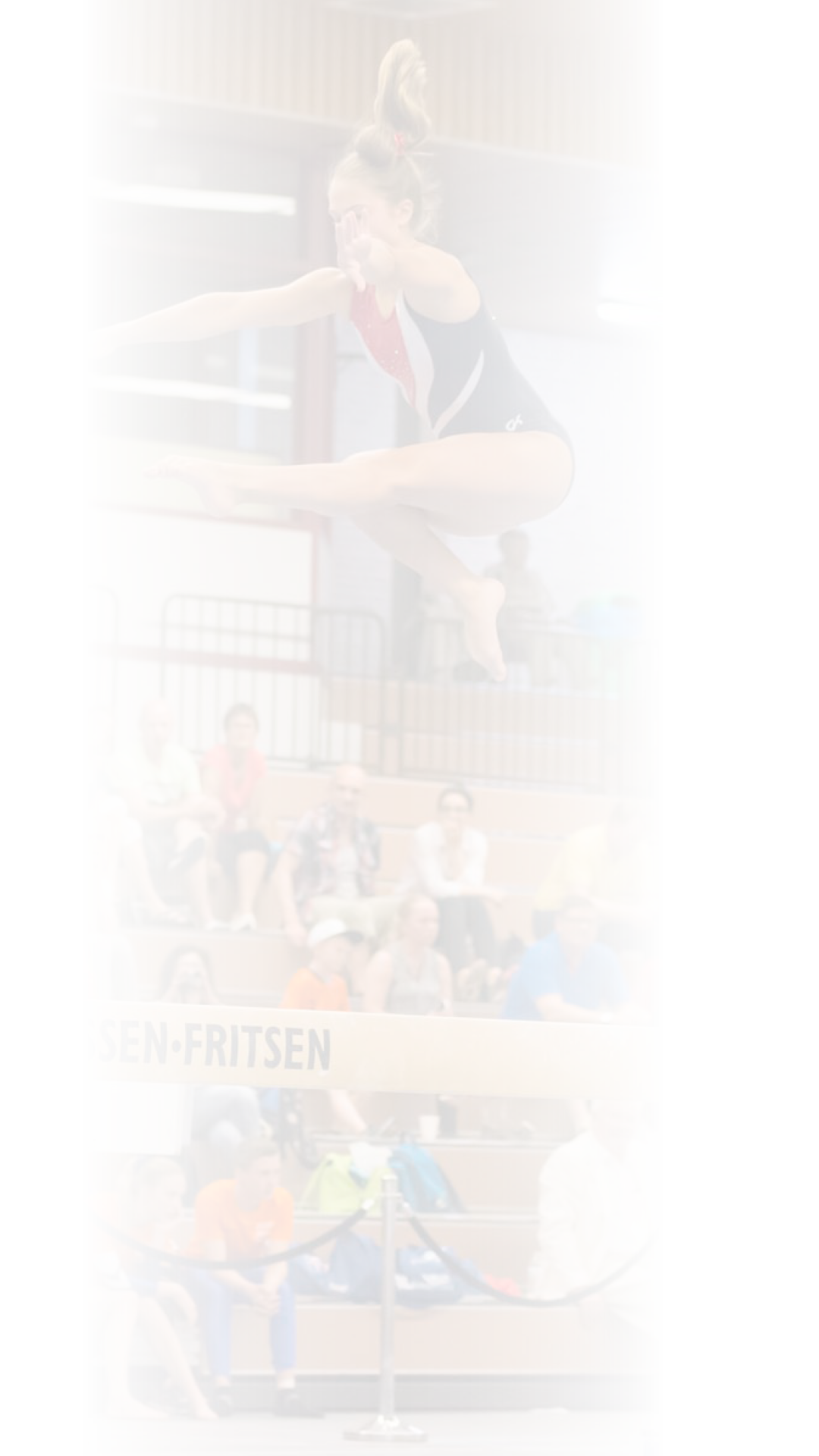 Alkmaar, the Netherlands - June 26, 2015: A young female gymnast is performing her balance beam routine during the International Children Games 2015. She is jumping and captured in the air. ICG is an international sports competition for children between 12 and 15 years old. In 2015 it has been held in Alkmaar.