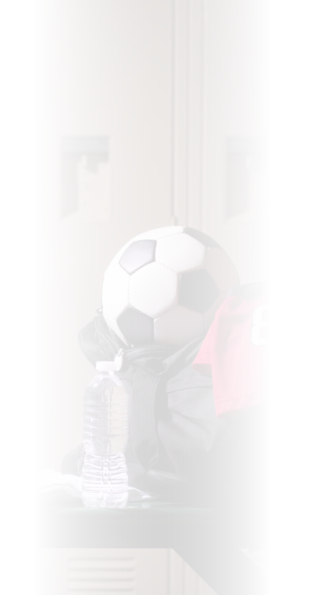 Various sports equipment on bench inside high school or college gymnasium locker room.  Items include: basketball, jersey, water, towel, gym bag..