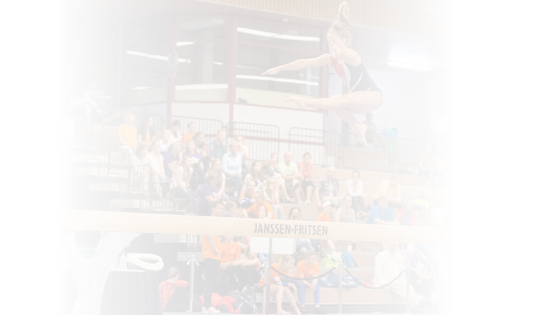 Alkmaar, the Netherlands - June 26, 2015: A young female gymnast is performing her balance beam routine during the International Children Games 2015. She is jumping and captured in the air. ICG is an international sports competition for children between 12 and 15 years old. In 2015 it has been held in Alkmaar.