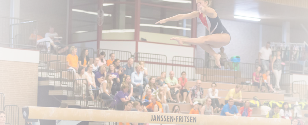 Alkmaar, the Netherlands - June 26, 2015: A young female gymnast is performing her balance beam routine during the International Children Games 2015. She is jumping and captured in the air. ICG is an international sports competition for children between 12 and 15 years old. In 2015 it has been held in Alkmaar.