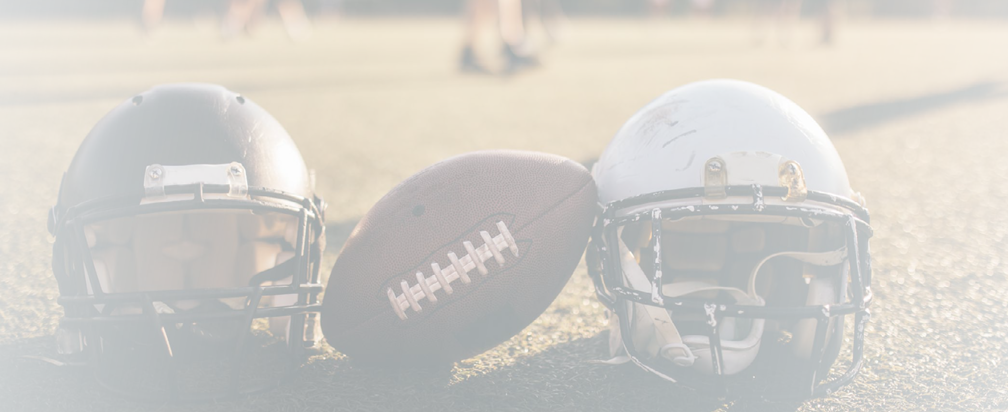 American football helmets and ball on the playing field.